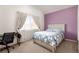 Bedroom featuring bed with a patterned comforter, pastel wall, window, and desk at 8117 Horizon Lake Dr, Las Vegas, NV 89128