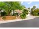 Home with a three car garage, tile roof, desert landscaping and a large shade tree at 8117 Horizon Lake Dr, Las Vegas, NV 89128