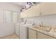 Functional laundry room with a sink, cabinets, and a washer and dryer at 8117 Horizon Lake Dr, Las Vegas, NV 89128