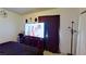 Bedroom with dark wooden dresser, TV, curtains, and beige carpet at 833 Bruce St, Las Vegas, NV 89101