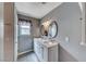 Bathroom featuring a double vanity with marble countertops, decorative mirrors, and soft gray walls at 902 Little Raven St, Henderson, NV 89002