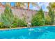 Inviting pool area with unique shell accents, lush landscaping and refreshing water feature at 902 Little Raven St, Henderson, NV 89002