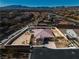 An aerial view of the property in a desert setting, showing the pool, patio and surrounding desert landscape at 9091 Becket Ranch Ct, Las Vegas, NV 89113