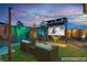 Cozy backyard seating area with an outdoor television and ambient lighting, perfect for outdoor relaxation and entertainment at 9091 Becket Ranch Ct, Las Vegas, NV 89113