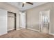 A bedroom with neutral walls, carpeted floors, a ceiling fan, white closet doors, and an entrance to the ensuite bathroom at 9091 Becket Ranch Ct, Las Vegas, NV 89113