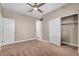 A bedroom with carpet, neutral walls, ceiling fan, white closet doors and doors leading to other rooms at 9091 Becket Ranch Ct, Las Vegas, NV 89113