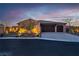Charming single-story home showcasing a three-car garage and landscaped front yard with tasteful exterior lighting at 9091 Becket Ranch Ct, Las Vegas, NV 89113