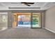 Bright living room with a ceiling fan and sliding glass doors leading to a private pool at 9091 Becket Ranch Ct, Las Vegas, NV 89113