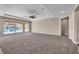 Spacious, neutral-toned living room with large sliding glass doors offering views of the backyard swimming pool at 9091 Becket Ranch Ct, Las Vegas, NV 89113