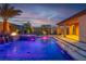 Beautiful backyard pool with spa, waterfall feature, and ambient lighting for evening relaxation at 9091 Becket Ranch Ct, Las Vegas, NV 89113