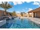 A luxurious pool with a spa, rock waterfall feature, and a desert-landscaped backyard for ultimate relaxation at 9091 Becket Ranch Ct, Las Vegas, NV 89113