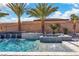 This backyard boasts a sparkling pool with water features and is surrounded by lush landscaping and palm trees at 9091 Becket Ranch Ct, Las Vegas, NV 89113
