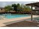 Community pool featuring lounge chairs and covered area for relaxation by the shimmering water at 9145 Ebony Threads Ct, Las Vegas, NV 89149