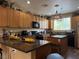 Spacious kitchen offers wood cabinetry, granite countertops, an island, and modern appliances at 9145 Ebony Threads Ct, Las Vegas, NV 89149
