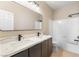 Bright bathroom featuring a double sink vanity with modern fixtures and a shower-tub combination at 9916 Dusty Winds Ave, Las Vegas, NV 89117