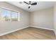 Well-lit bedroom with modern fan and window, complemented by wood-look floors for a cozy atmosphere at 9916 Dusty Winds Ave, Las Vegas, NV 89117