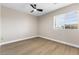 Well-lit bedroom with wood-look floors and modern ceiling fan, provides a comfortable and stylish retreat at 9916 Dusty Winds Ave, Las Vegas, NV 89117