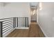 Hallway featuring modern lighting, railing and wood-look floors, providing a seamless flow between rooms at 9916 Dusty Winds Ave, Las Vegas, NV 89117