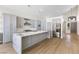 Open kitchen with granite island, gray cabinets, stainless steel appliances, and wood-style floors at 9916 Dusty Winds Ave, Las Vegas, NV 89117