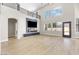 Open-concept living room featuring wood floors, a fireplace, and large windows for natural light at 9916 Dusty Winds Ave, Las Vegas, NV 89117