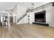 Open living space featuring wood floors, a modern fireplace, and access to the staircase at 9916 Dusty Winds Ave, Las Vegas, NV 89117
