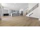 Bright and airy living space with wood floors, gray cabinets, kitchen island, and modern black shelving at 9916 Dusty Winds Ave, Las Vegas, NV 89117