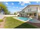 Backyard view of pool and spa with pristine landscaping and a two-story home at 9916 Dusty Winds Ave, Las Vegas, NV 89117