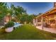 Expansive backyard with manicured lawn, lounge chairs, covered patio, and spa at 6316 Bluejay Way, Las Vegas, NV 89146