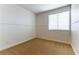 Cozy bedroom featuring neutral carpet, white walls, and a window for natural light at 10381 Walking View Ct, Las Vegas, NV 89135