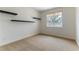 Neutral bedroom featuring dark floating shelves and a window for natural light at 10381 Walking View Ct, Las Vegas, NV 89135