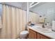 Bright bathroom featuring a shower with curtain, a sink and vanity with a large mirror and modern fixtures at 10547 Grazia Ave, Las Vegas, NV 89135