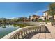 Community clubhouse overlooking pond and lush landscaping with palm trees and walking paths at 10547 Grazia Ave, Las Vegas, NV 89135