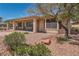 Exterior view of the home with a covered patio, desert landscaping, and mature trees at 10547 Grazia Ave, Las Vegas, NV 89135