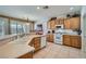 Bright kitchen with oak cabinets, tile floor, modern white appliances, and lots of natural light at 10547 Grazia Ave, Las Vegas, NV 89135