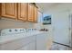 Efficient laundry room with cabinets, washer, dryer, and access to the exterior at 10547 Grazia Ave, Las Vegas, NV 89135
