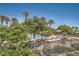 Community pool surrounded by mature trees, lush landscaping, lounge chairs and resort style umbrellas at 10547 Grazia Ave, Las Vegas, NV 89135