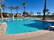 Resort-style pool with palm trees and lounge areas, perfect for relaxation and entertainment at 10547 Grazia Ave, Las Vegas, NV 89135
