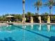 Sparkling community swimming pool with plenty of lounge chairs and shaded seating areas at 10547 Grazia Ave, Las Vegas, NV 89135