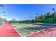 Well-maintained tennis court on a sunny day with greenery and fencing around the perimeter at 10547 Grazia Ave, Las Vegas, NV 89135