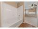 This bathroom features a shower over tub with white surround and wood-look floors at 10664 Mount Jefferson Ave, Las Vegas, NV 89166