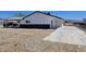 View of this single story home featuring back patio and driveway with black trim at 1083 E Calvada Blvd, Pahrump, NV 89048
