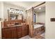Charming bathroom featuring double sinks, stylish vanity and a barn door leading to the bathtub at 11875 Maggie Ave, Las Vegas, NV 89166