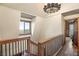 Upstairs hallway with a decorative chandelier, wood railing and a view of the landscape at 11875 Maggie Ave, Las Vegas, NV 89166