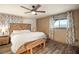 Comfortable main bedroom with a wooden headboard, bench, and ceiling fan at 11875 Maggie Ave, Las Vegas, NV 89166
