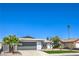 Single-story home with a well-manicured lawn, desert landscaping, and a gray two-car garage door at 4012 Mira Ln, Las Vegas, NV 89108