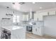Bright kitchen features stainless steel appliances, white cabinets, breakfast bar and pendant lighting at 4012 Mira Ln, Las Vegas, NV 89108