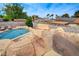 Backyard pool with a rock waterfall feature and slide, with lounge chairs for relaxation at 4578 Churchfield Cir, Las Vegas, NV 89103