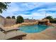 Backyard pool featuring rock waterfall, lush landscaping and comfortable lounge chairs at 4578 Churchfield Cir, Las Vegas, NV 89103