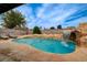 Backyard pool featuring rock waterfall, lush landscaping and comfortable lounge chairs at 4578 Churchfield Cir, Las Vegas, NV 89103
