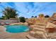 Backyard pool featuring rock waterfall, lush landscaping and comfortable lounge chairs at 4578 Churchfield Cir, Las Vegas, NV 89103
